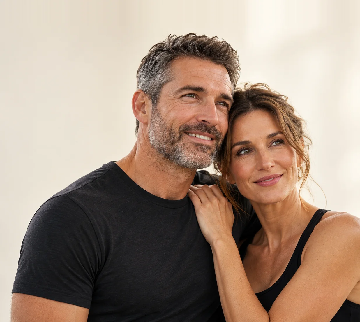 Smiling couple close together, her hand resting on his shoulder